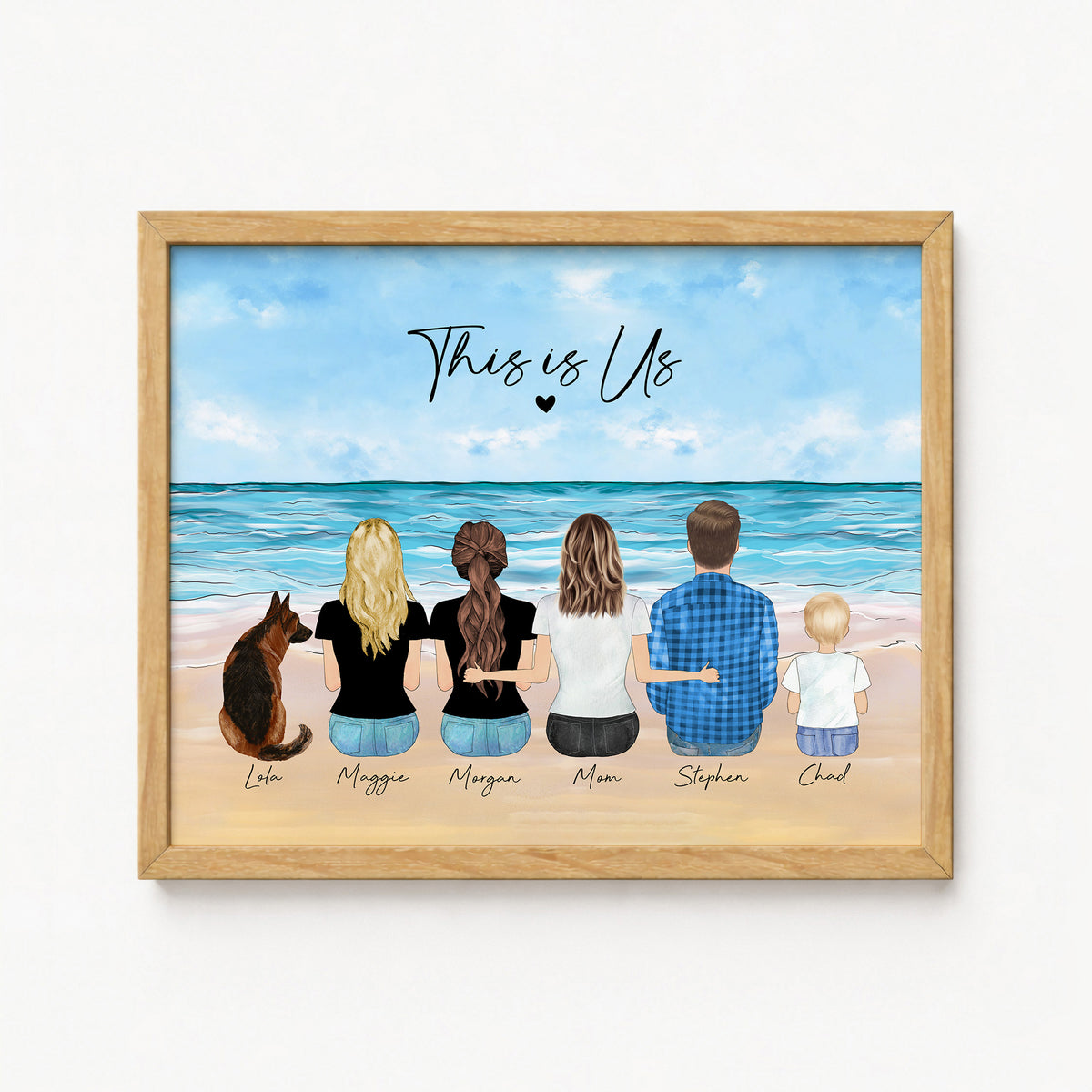 A personalized wooden framed art print featuring a watercolor illustration of a family of six with their dog from behind, sitting on a beach. The text 'This is Us' is written above them, with each family member's name and the dog's name written below in cursive.
